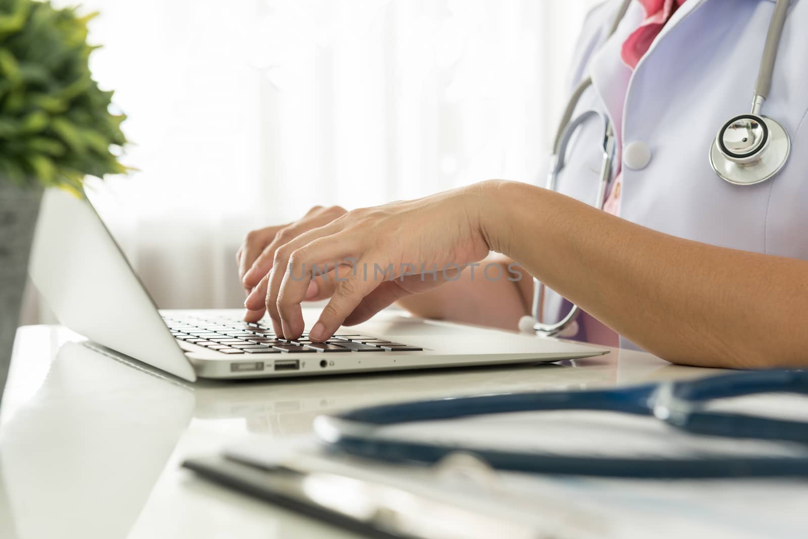 Close-up of a doctor typing on keybord in the office
