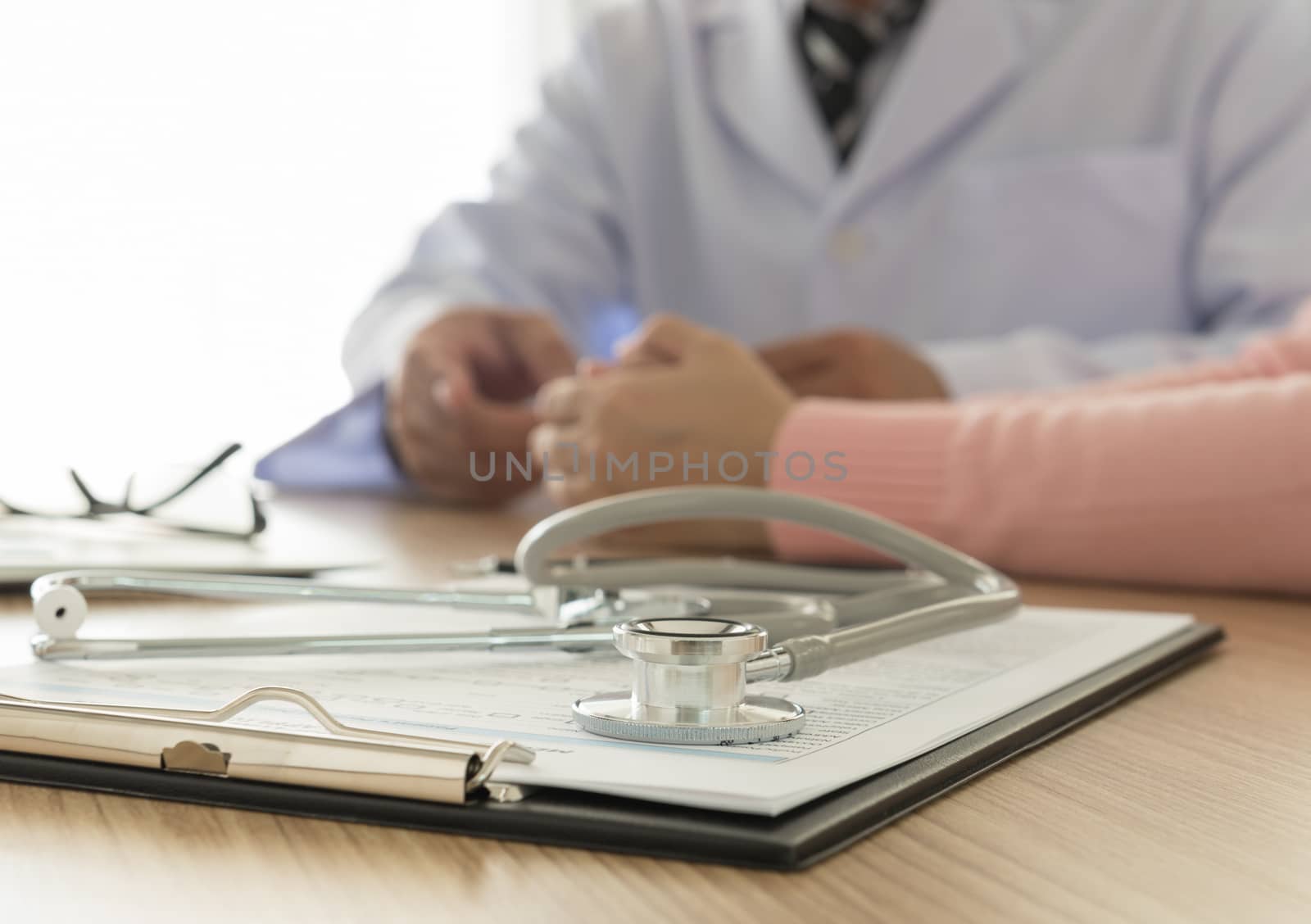 stethoscope and medical documentation  with doctor and patient background
