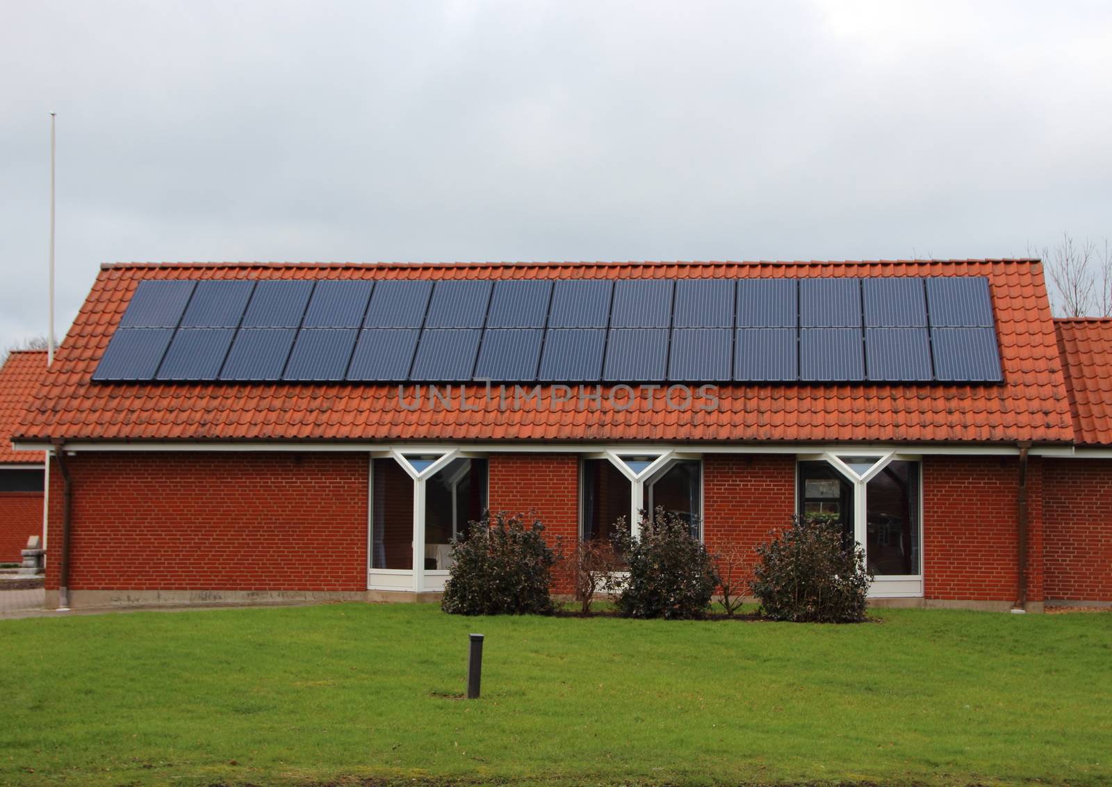 Sun Solar Panel Power Cell on Roof of Red House