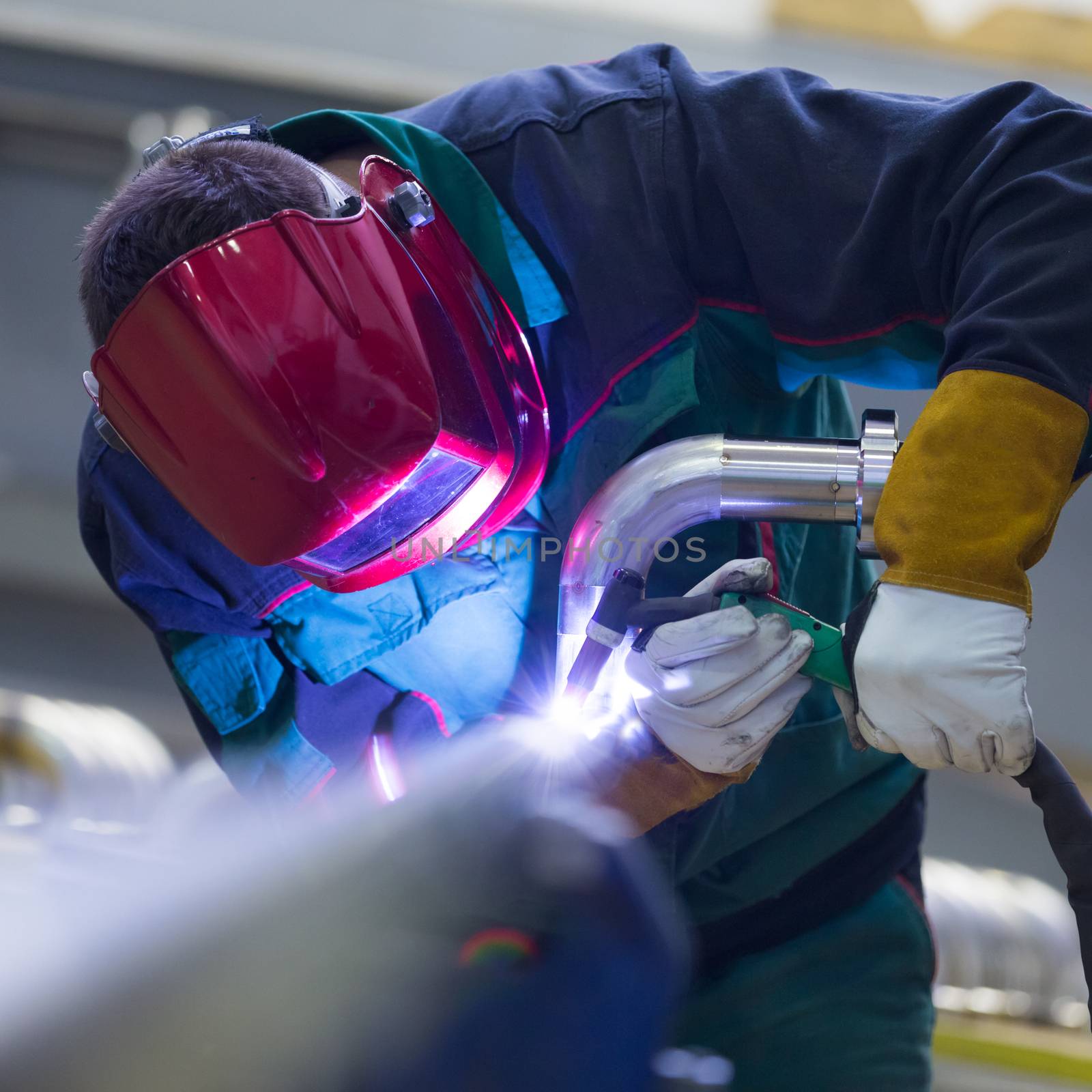 Industrial worker welding in metal factory. by kasto