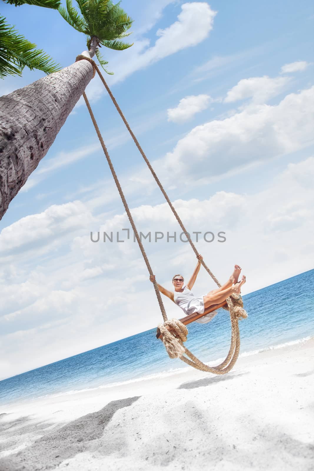 View of nice tropical  beach  with  girl on swing