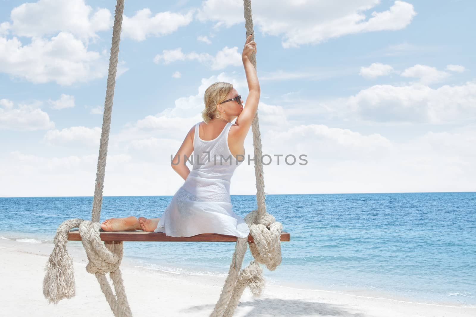 View of nice tropical  beach  with  girl on swing