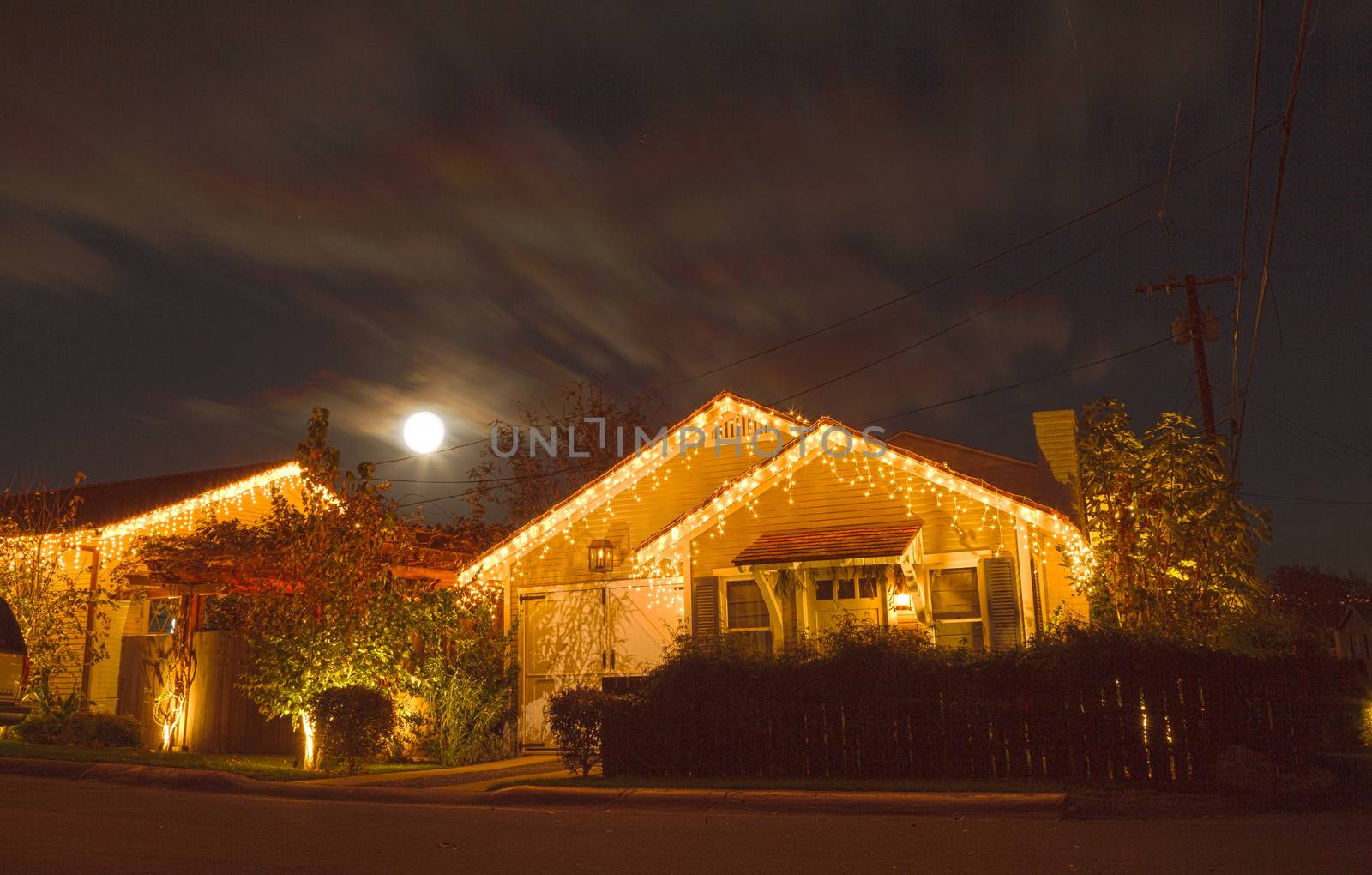 Full moon over a cottage with Christmas lights by steffstarr