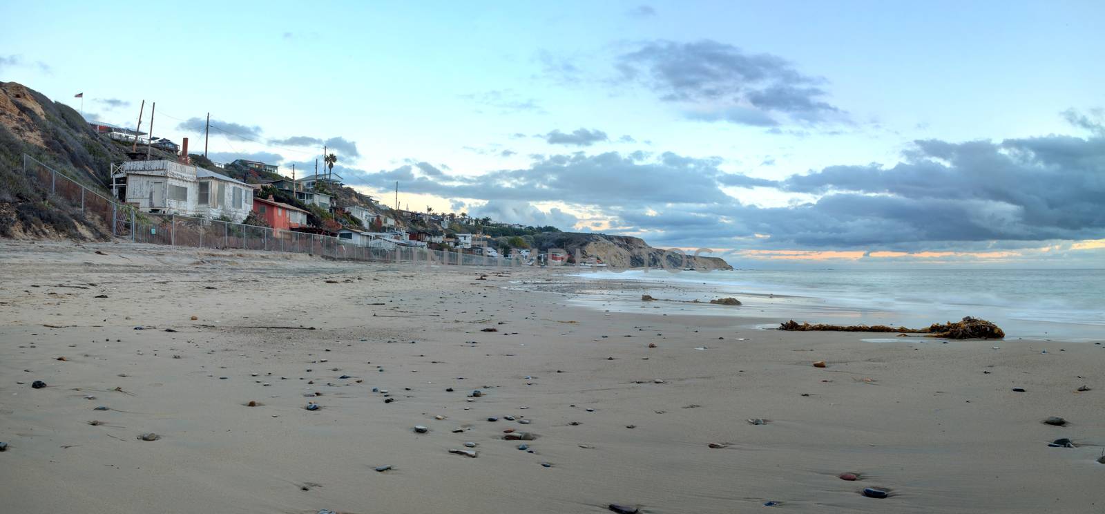 Cottages along Crystal Cove Beach, on the Newport Beach and Laguna Beach line in Southern California at sunset with a rainstorm looming.