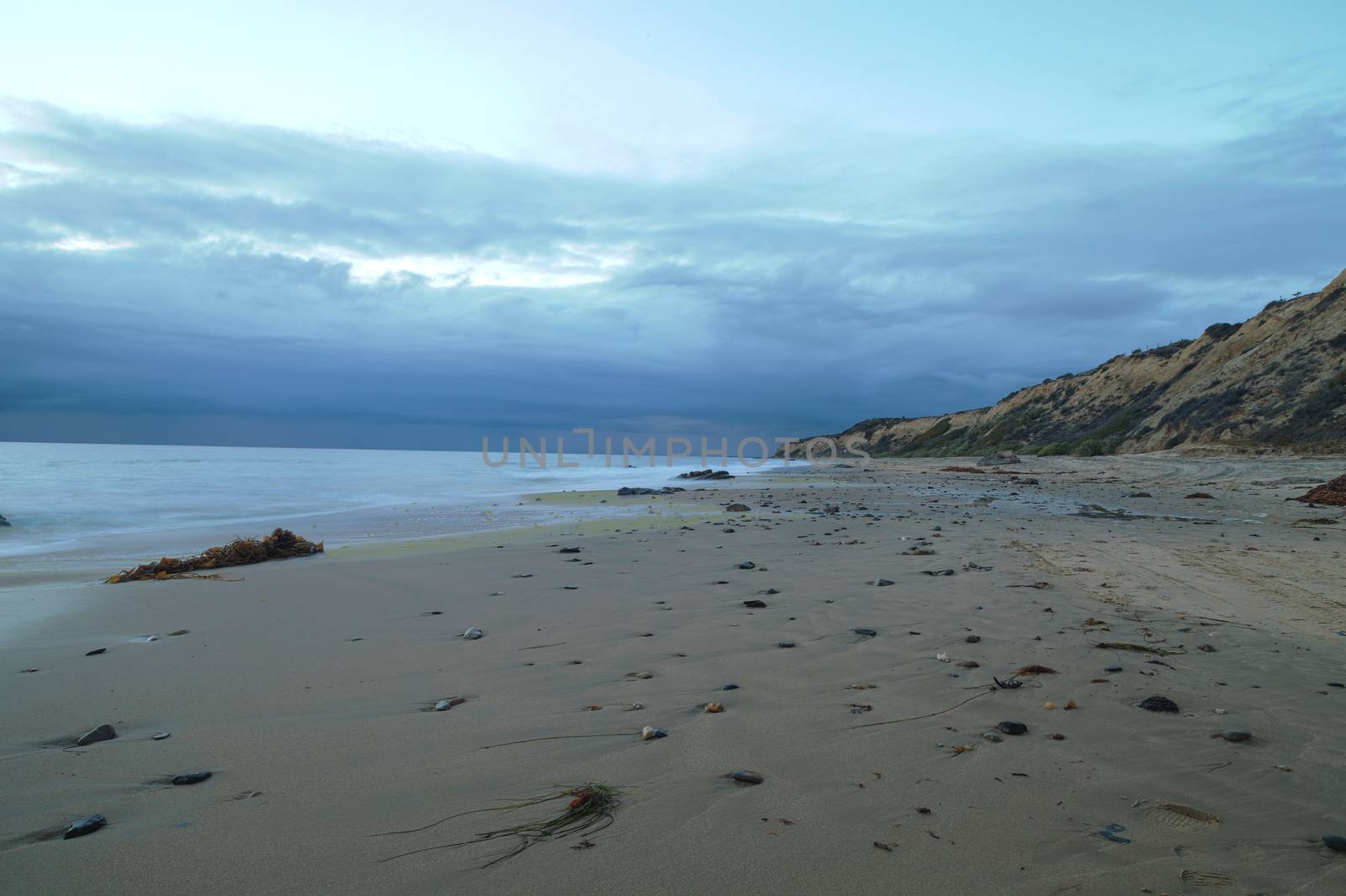 Rain clouds approach Crystal Cove Beach from the ocean, on the Newport Beach and Laguna Beach line in Southern California at sunset