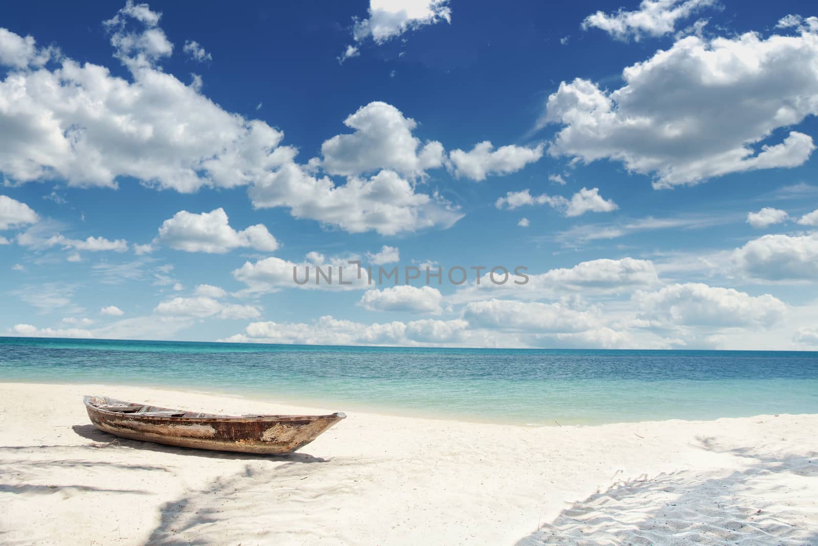 View of nice tropical  beach  with old boat and  some palm's shadows  around