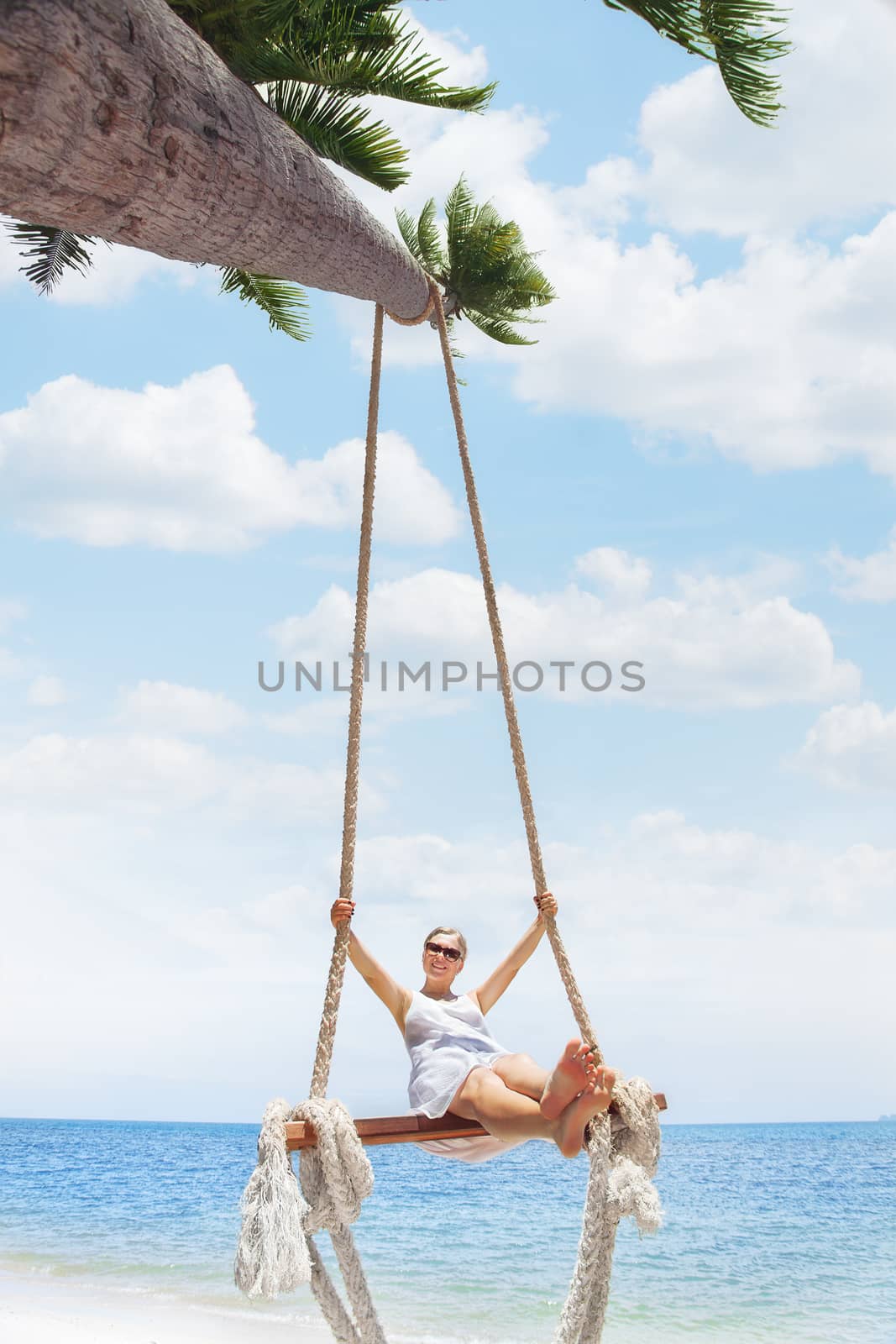 View of nice tropical  beach  with  girl on swing