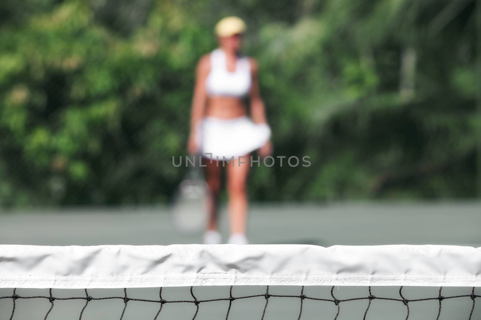 close up view of tennis net with player on the back. focused on the net