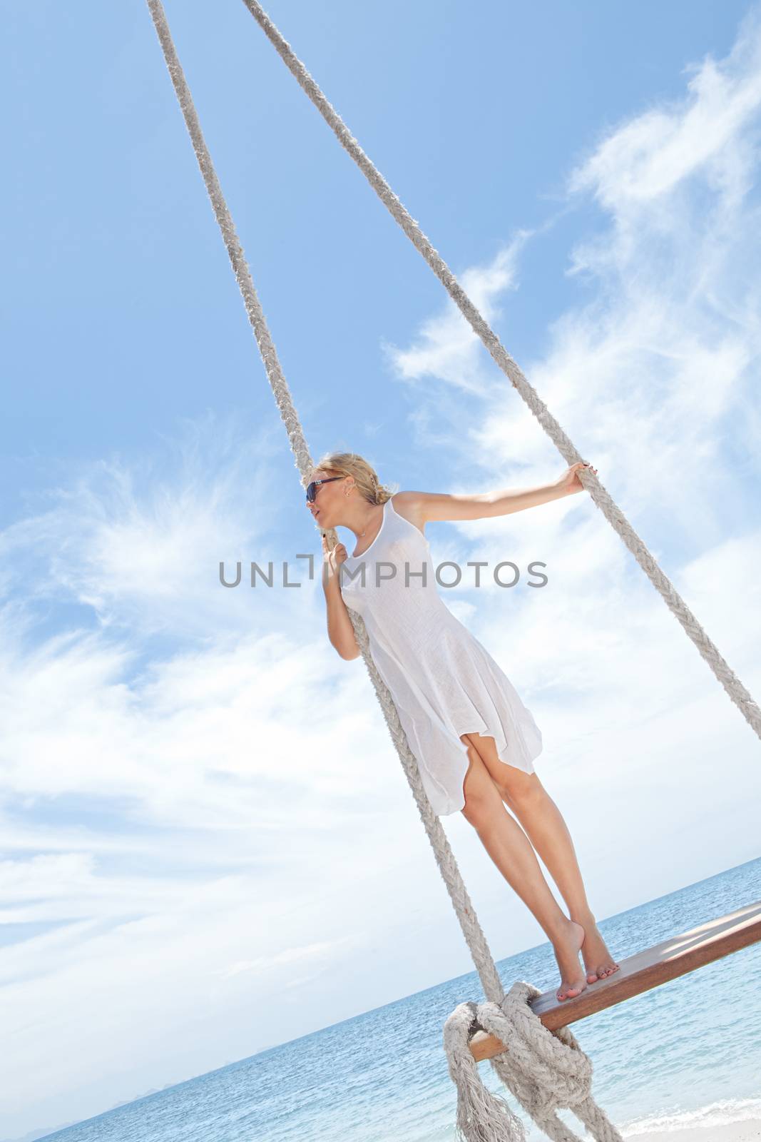 View of nice tropical  beach  with  girl on swing