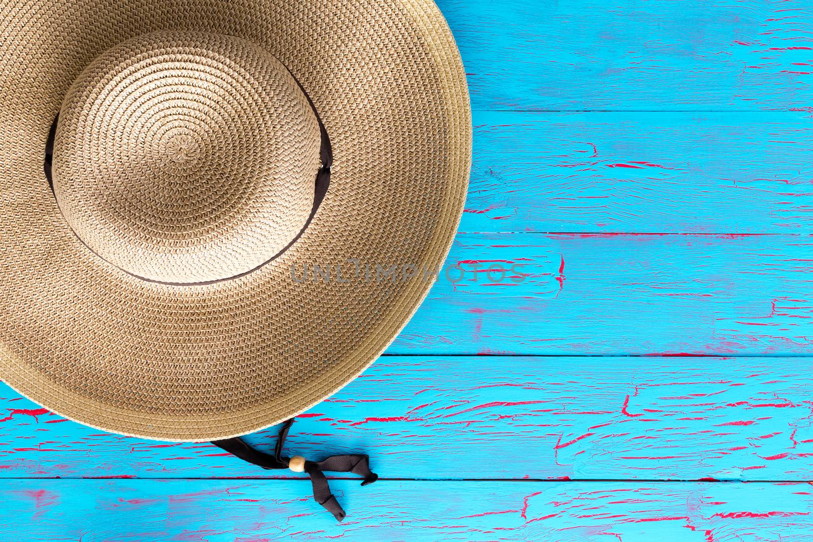 Wide brimmed straw gardening hat on a picnic table by coskun