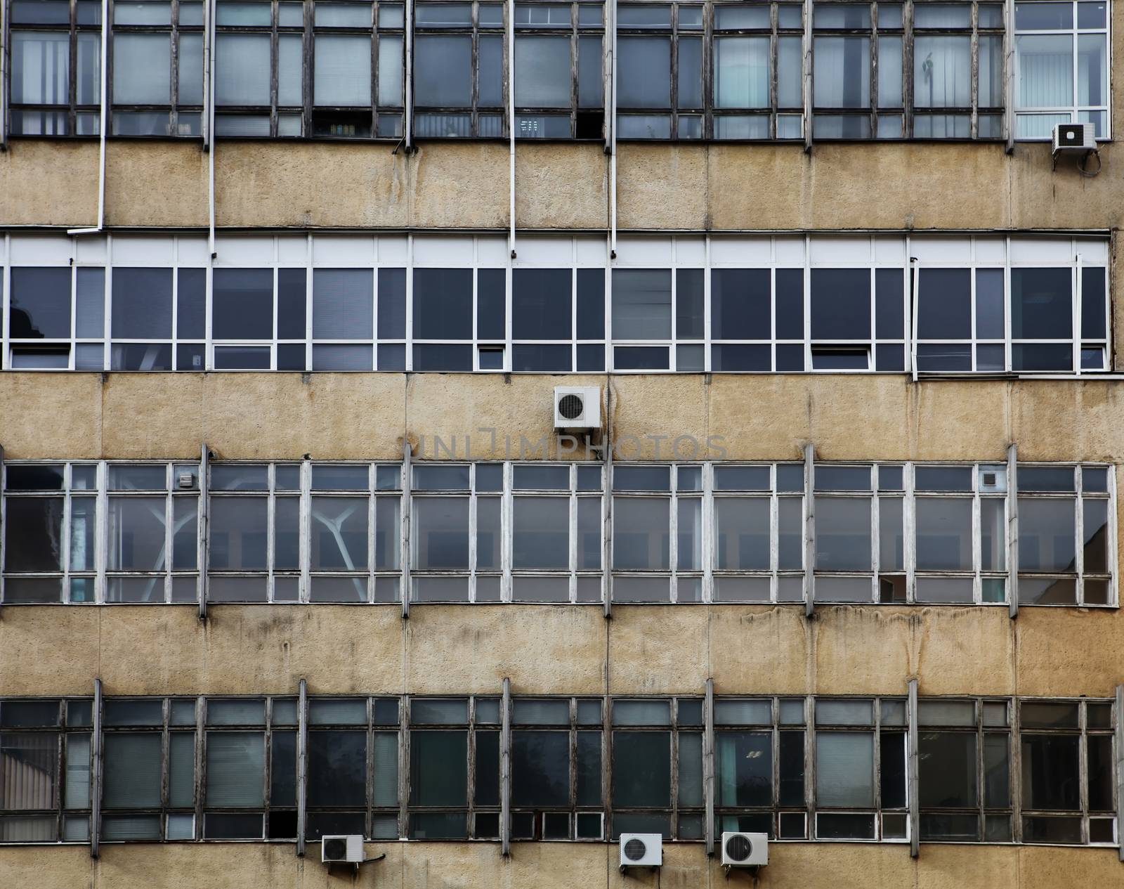 dirty old facade with windows of factory,