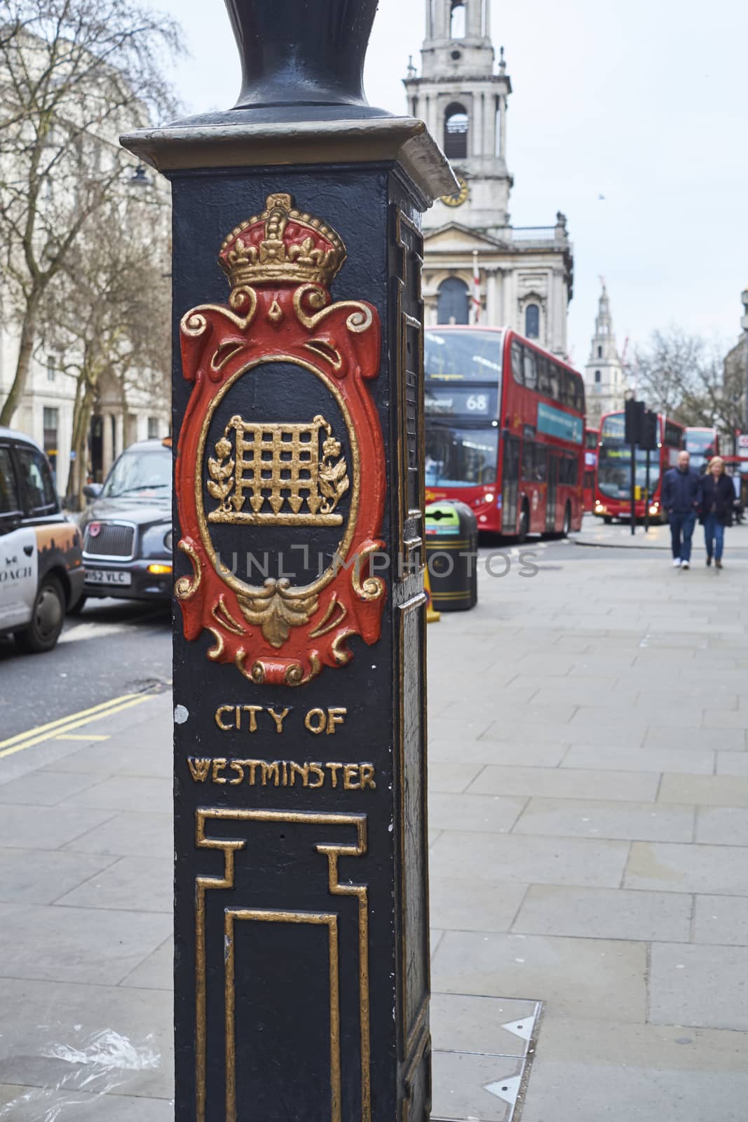 LONDON, UK - DECEMBER 20: Detail of light post in front of Sommerset House depicting the City of Westminster coat of arms and red double-decker bus in the background. December 20, 2015 in London.