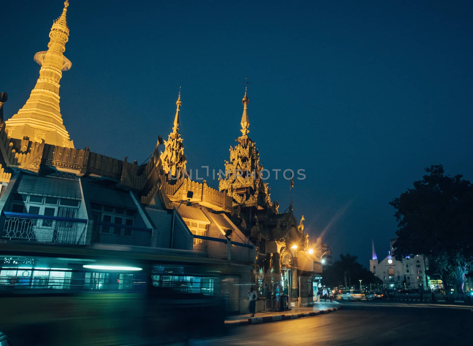 Sule Pagoda located in the heart of Yangon, Myanmar, Burma. Traffic is shown moving with blur to show action.