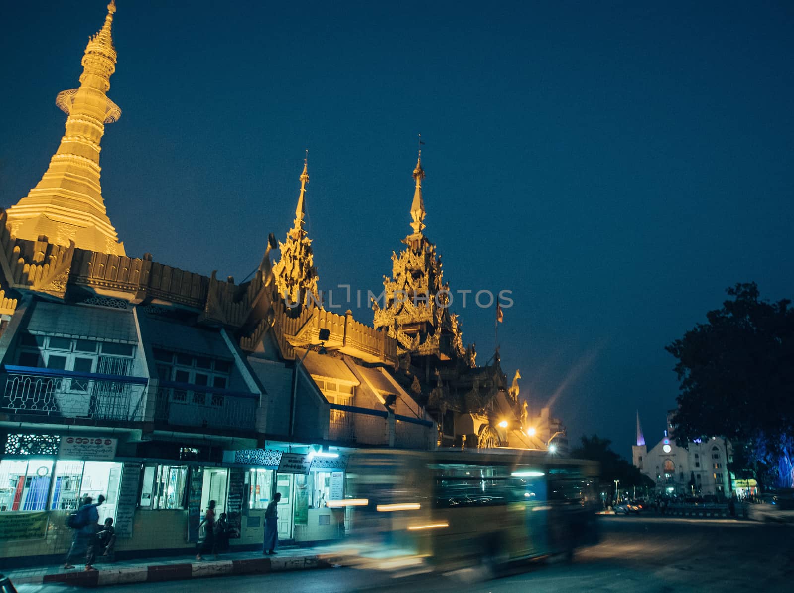 Sule Pagoda located in the heart of Yangon, Myanmar, Burma. Traffic is shown moving with blur to show action.