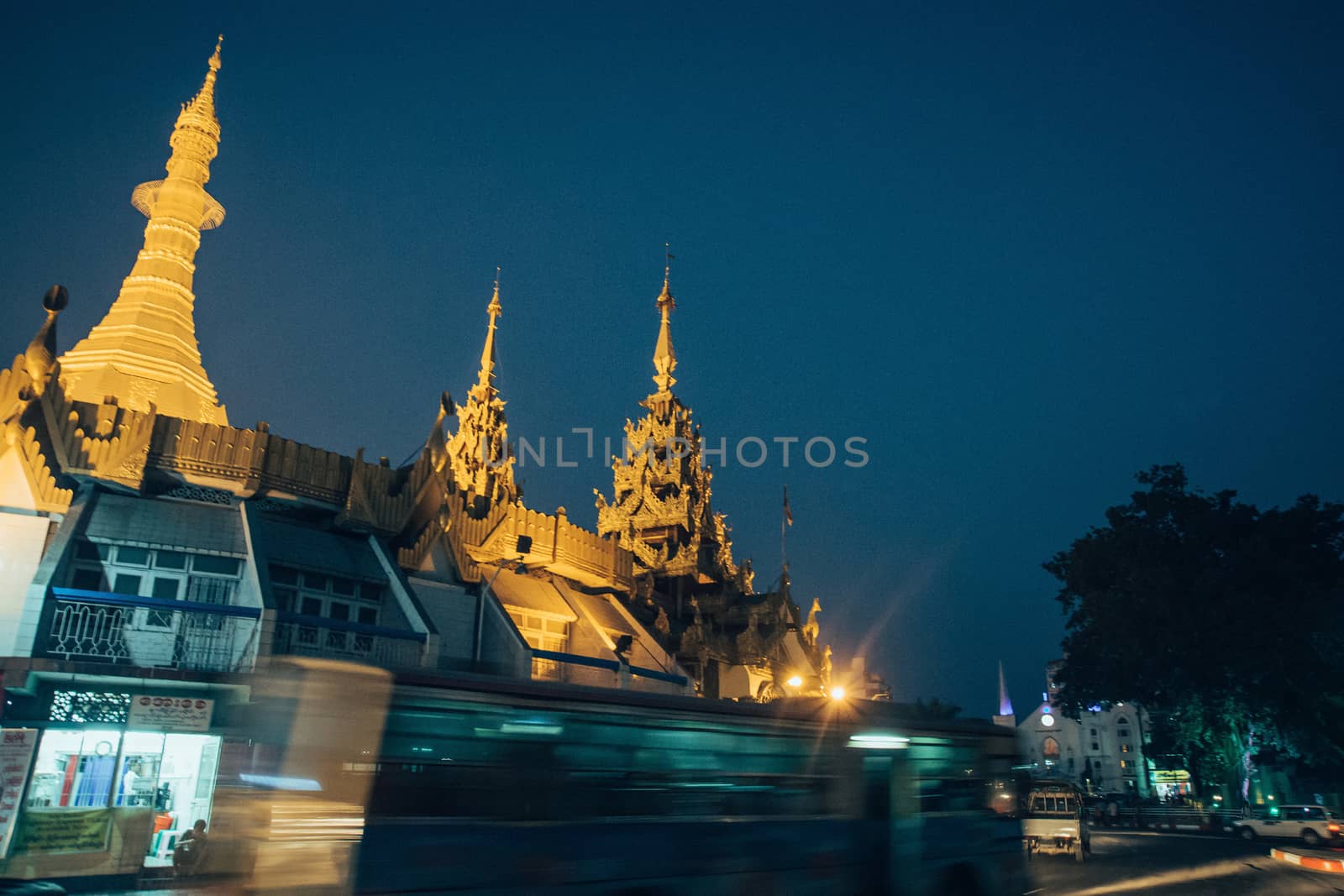 Sule Pagoda located in the heart of Yangon, Myanmar, Burma. Traffic is shown moving with blur to show action.