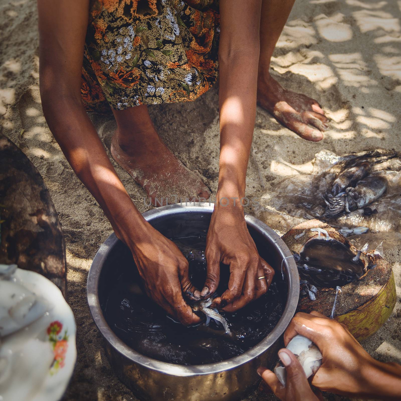 A woman is cleaning and preparing fresh caught squid for a meal.