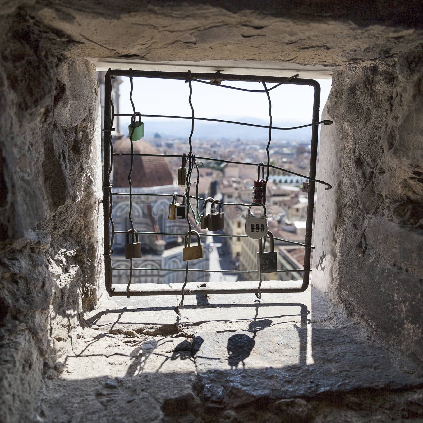 view from the barred windows with padlocks clock tower of the Basilica di Santa Maria del Fiore, Florence, Italy