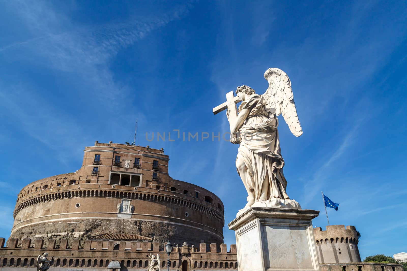 Vıew of Castel Sant'Angelo, Castle of the Holy Angel built by Hadrian in Rome, with a sculpture, on bright blue sky background.