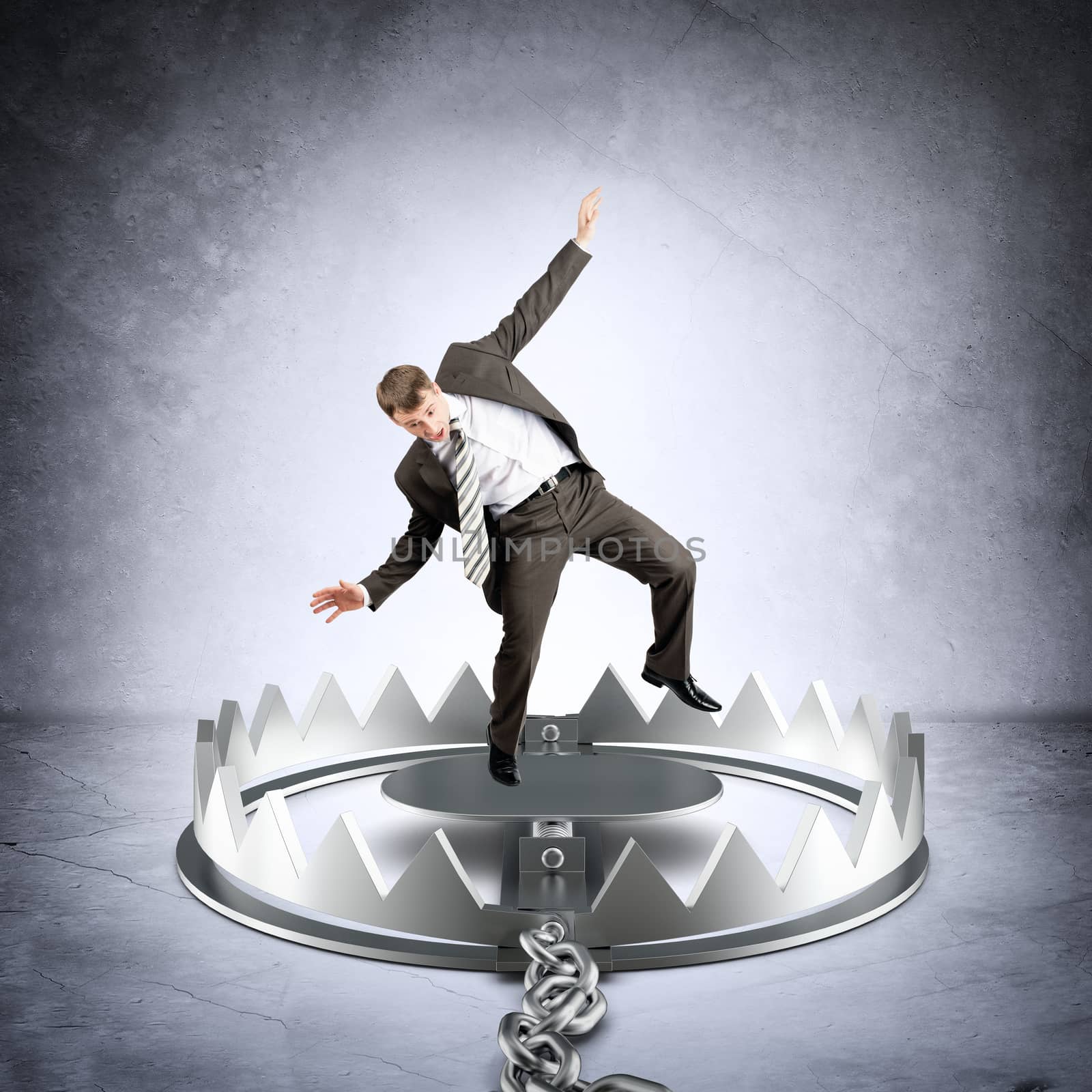 Businessman in bear trap on grey wall background, danger concept