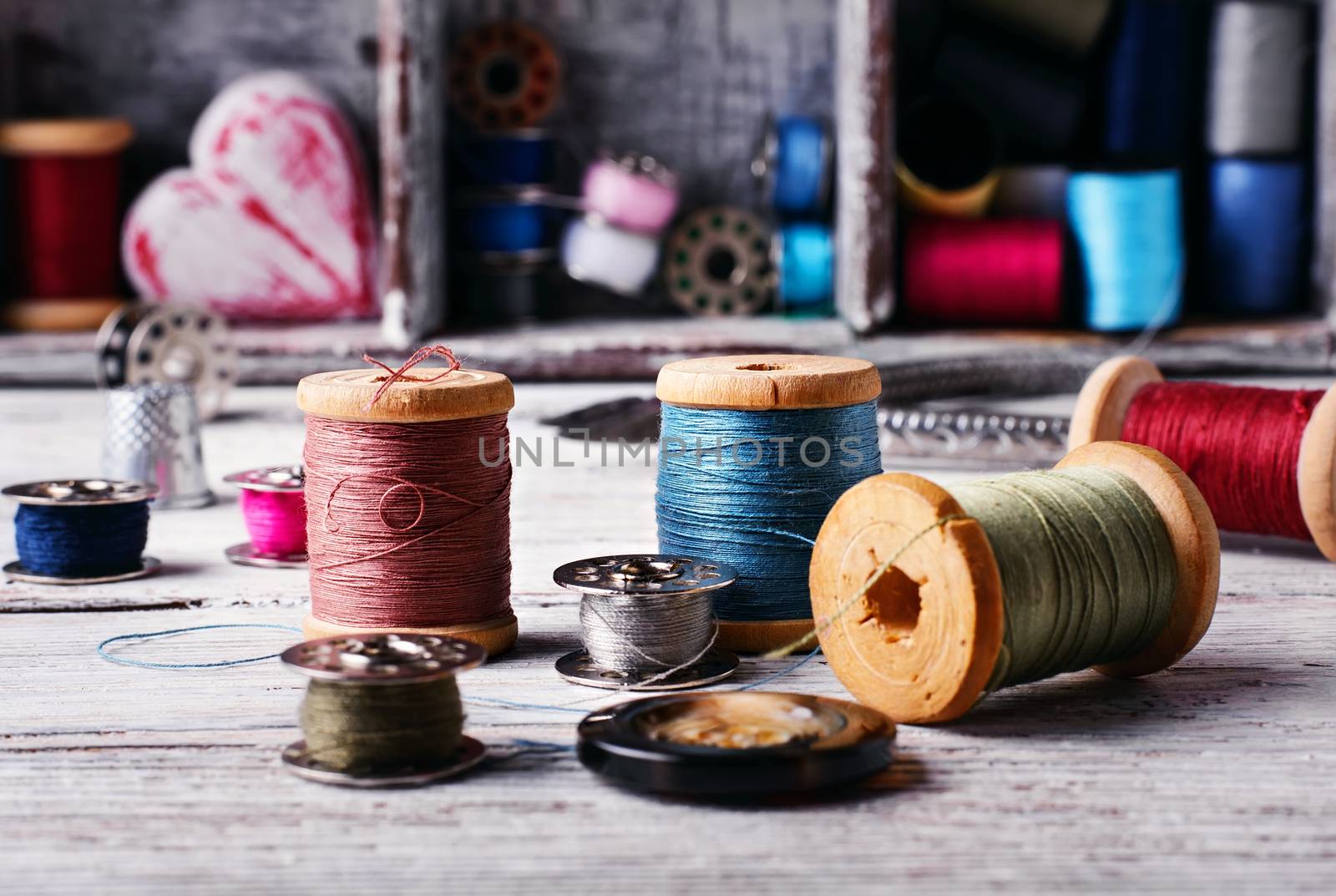 Beads,thread and bobbins for needlework.Selective focus