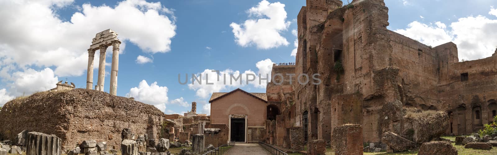 View of archeological area of ancient Roman Forum in Rome, on cloudy blue sky background.