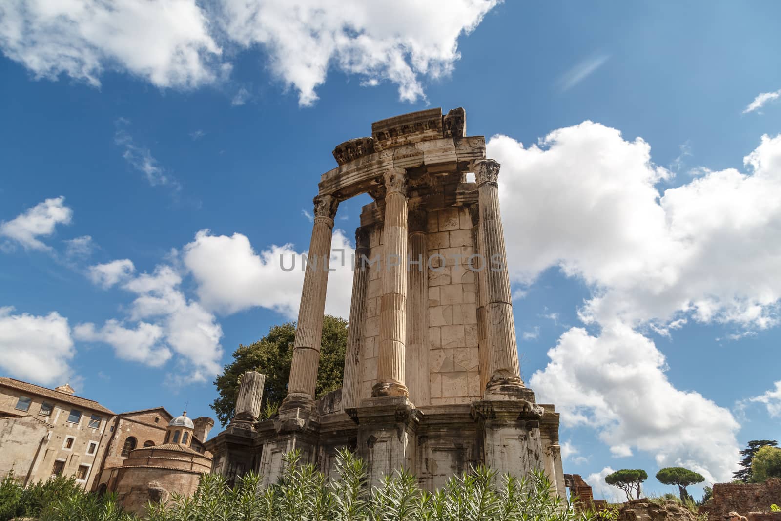 View of archeological area of ancient Roman Forum in Rome, on cloudy blue sky background.