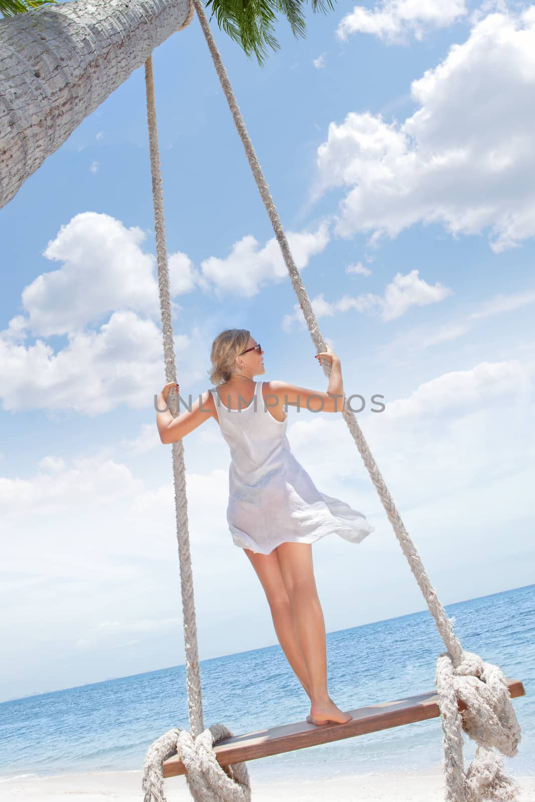 View of nice tropical  beach  with  girl on swing