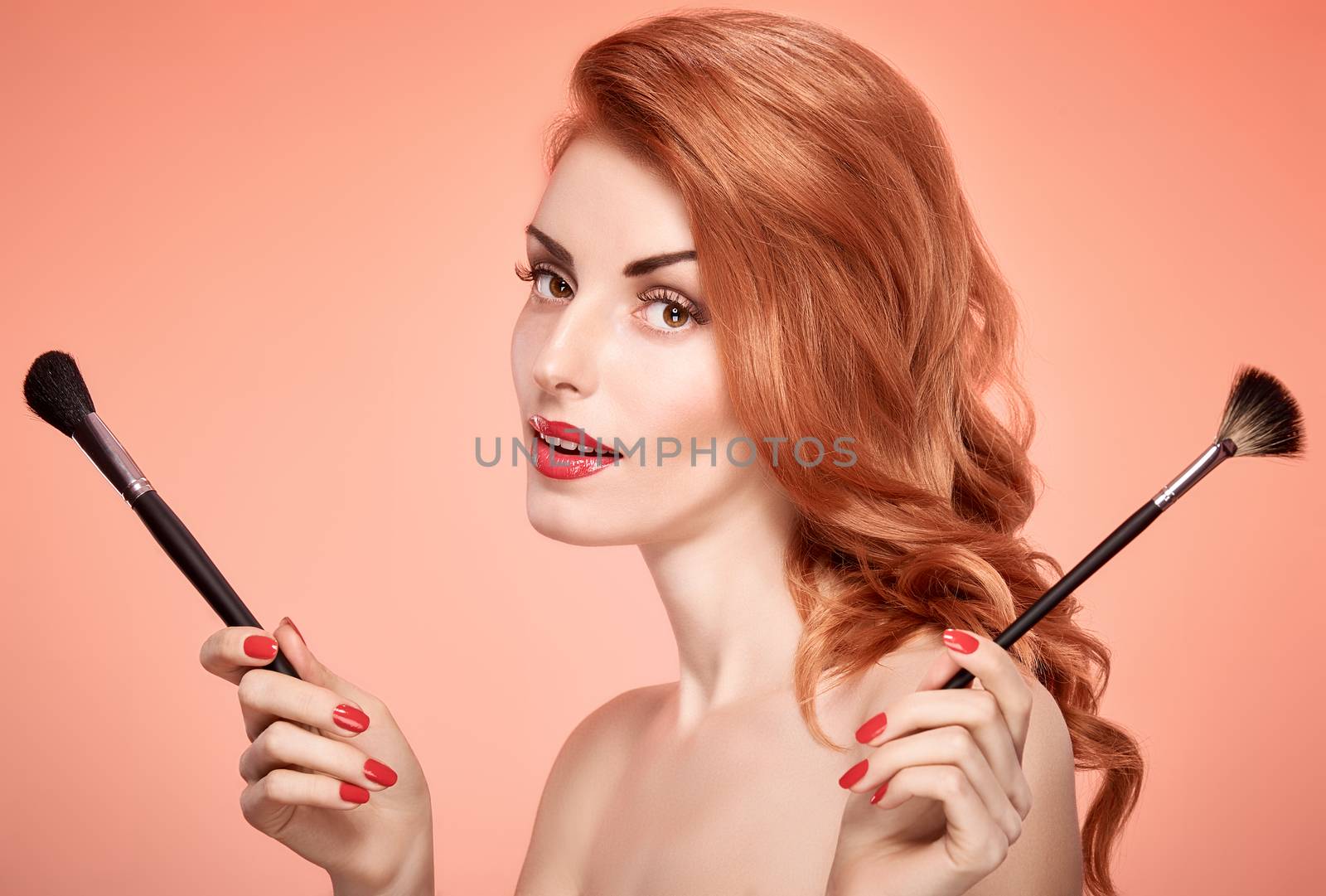 Beauty portrait nude woman smiling, eyelashes, perfect skin, red lips, fashion.Gorgeous sensual attractive pretty redhead sexy model girl with makeup brushes on pink, shiny wavy hair.People, copyspace