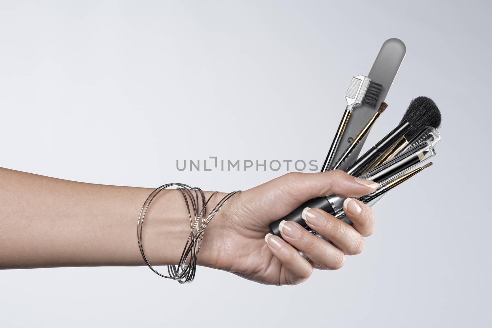 Close up on woman’s hand holding cosmetic theme objects