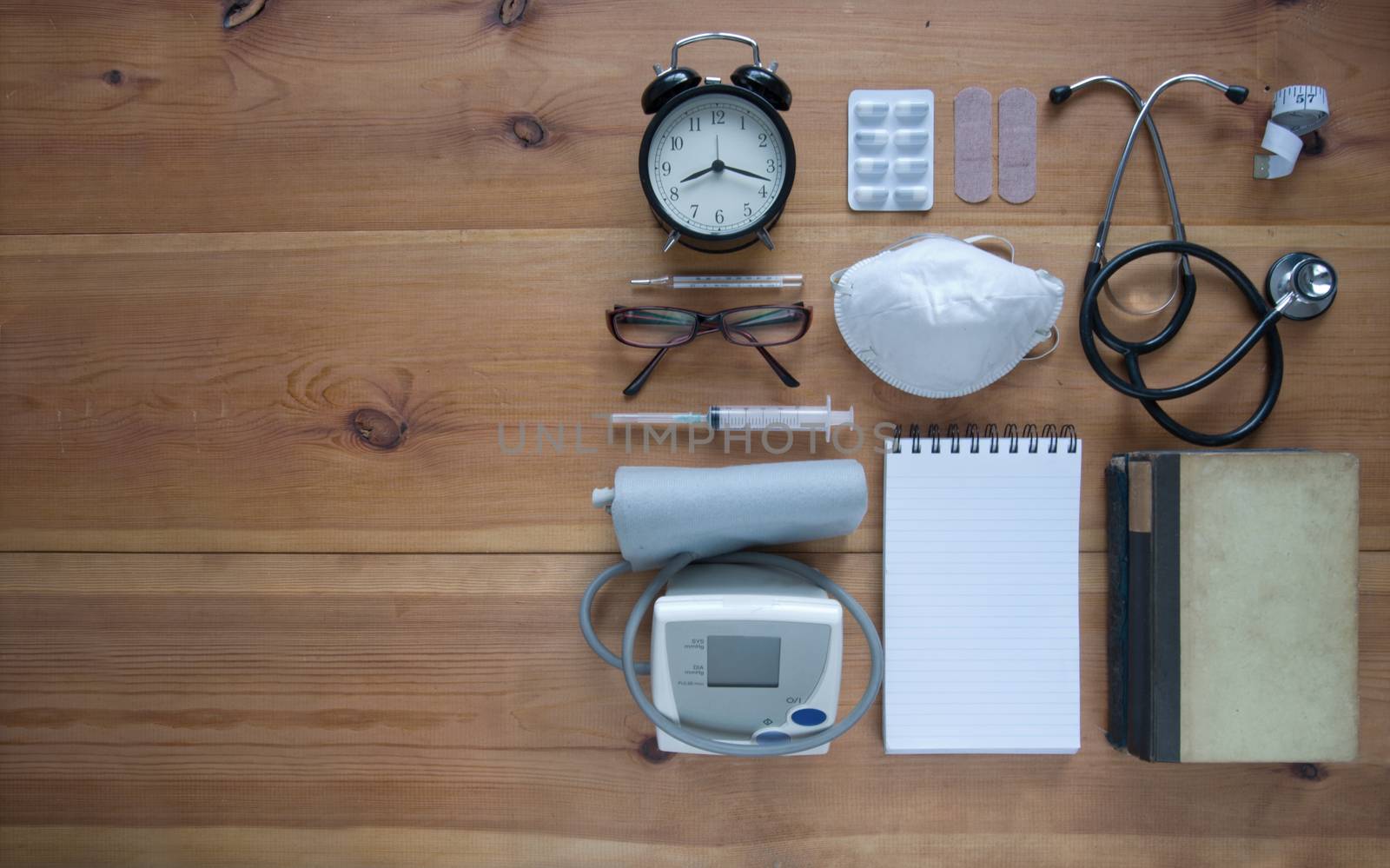 Medical objects laid out on a wooden table with space