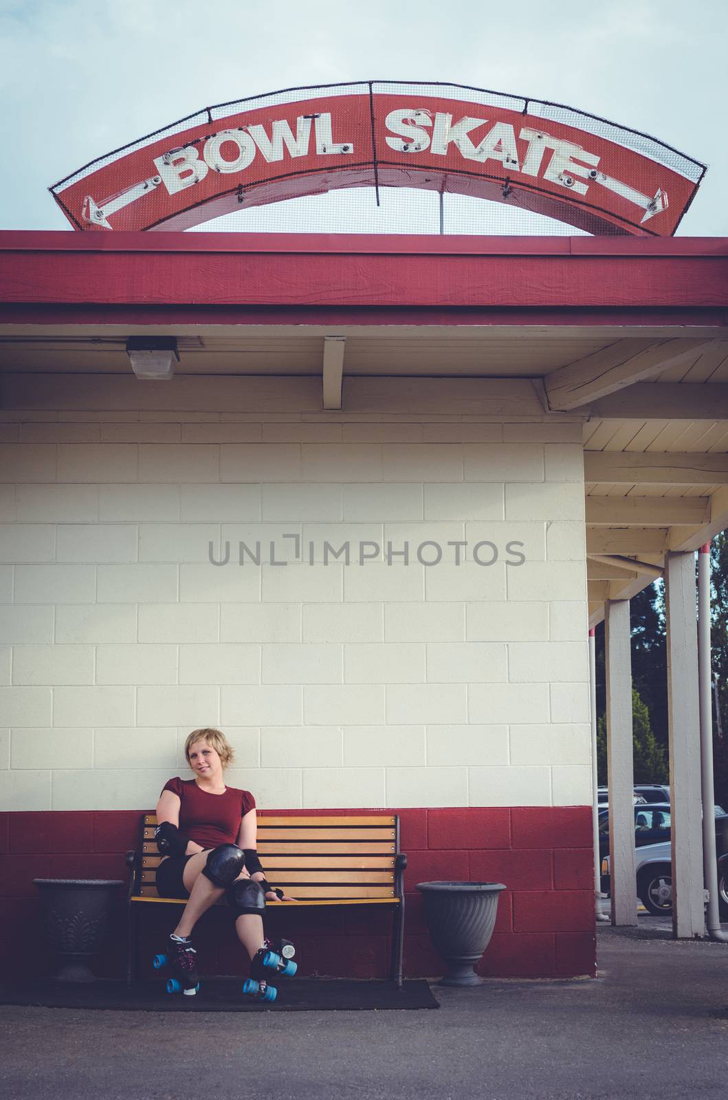 Woman on roller skates outside of a roller rink.