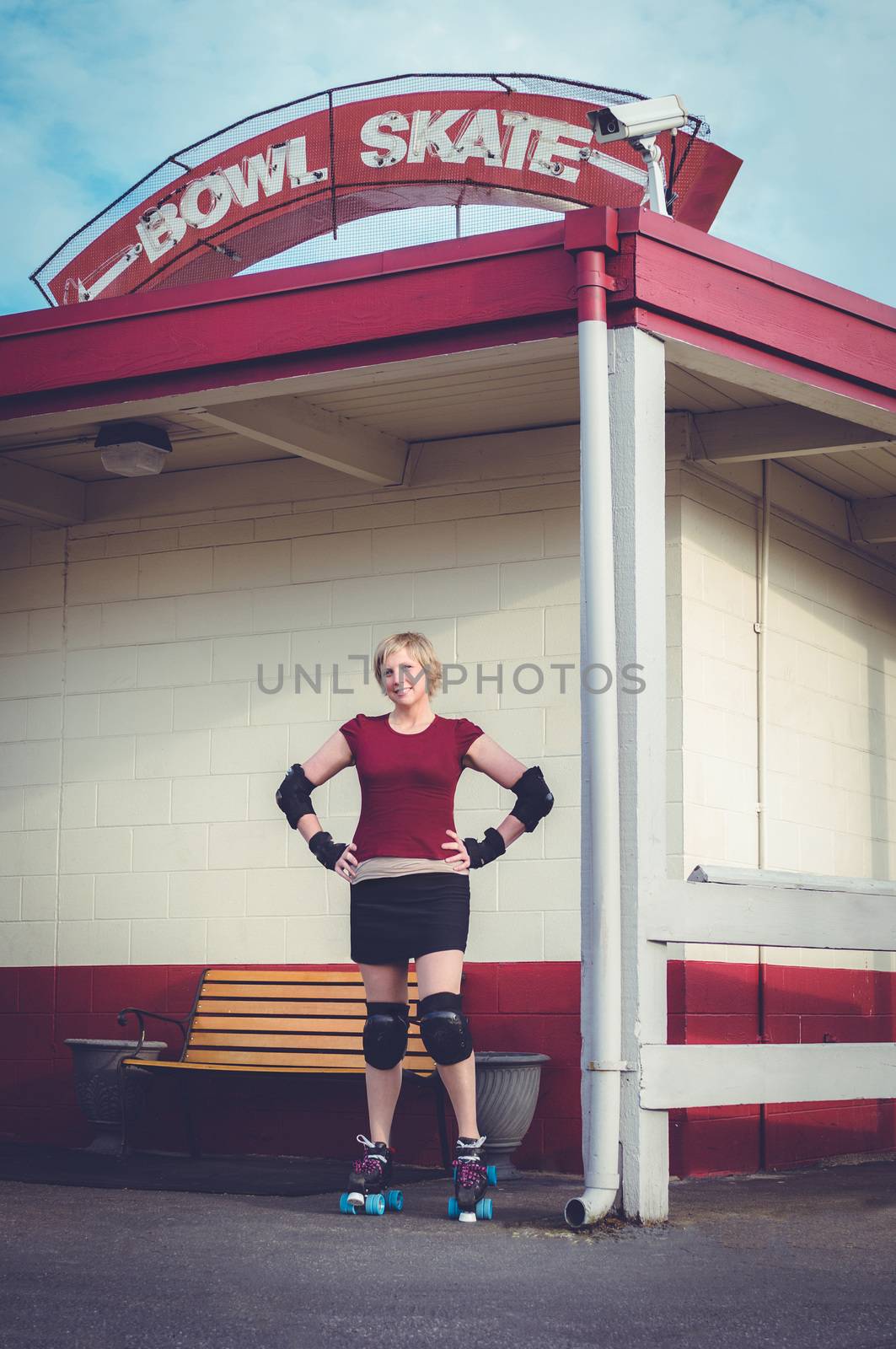 Woman on roller skates outside of a roller rink.