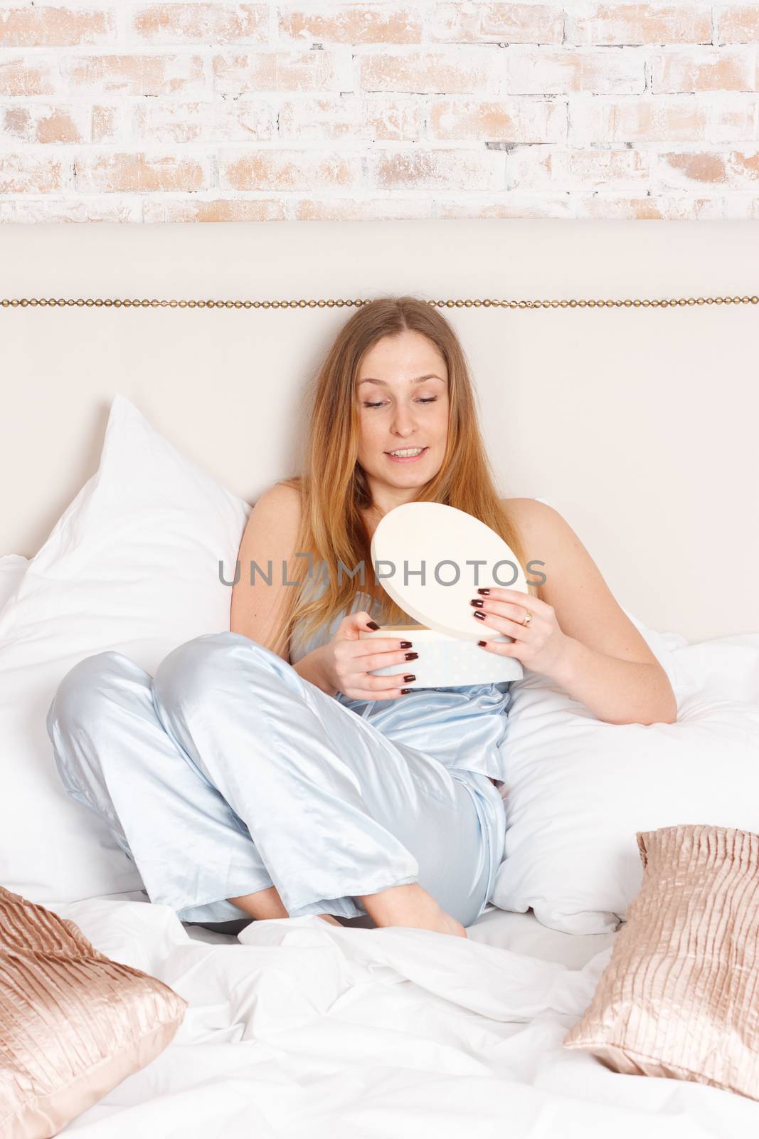 young woman in blue pajamas in white bedding