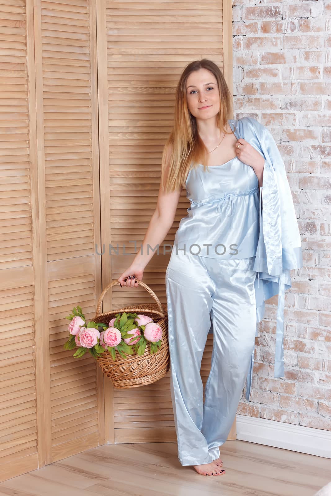 Beautiful young woman and bascket with flowers