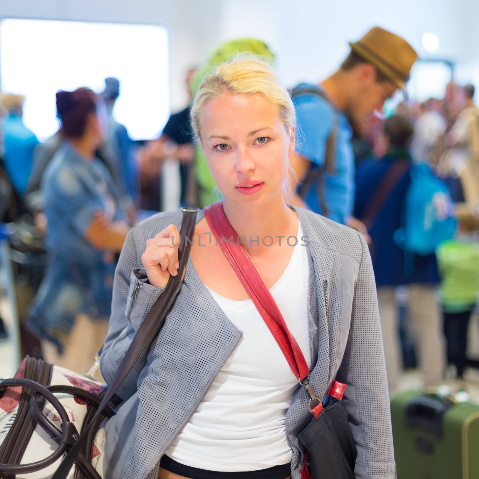 Female traveller waiting in airport terminal. by kasto