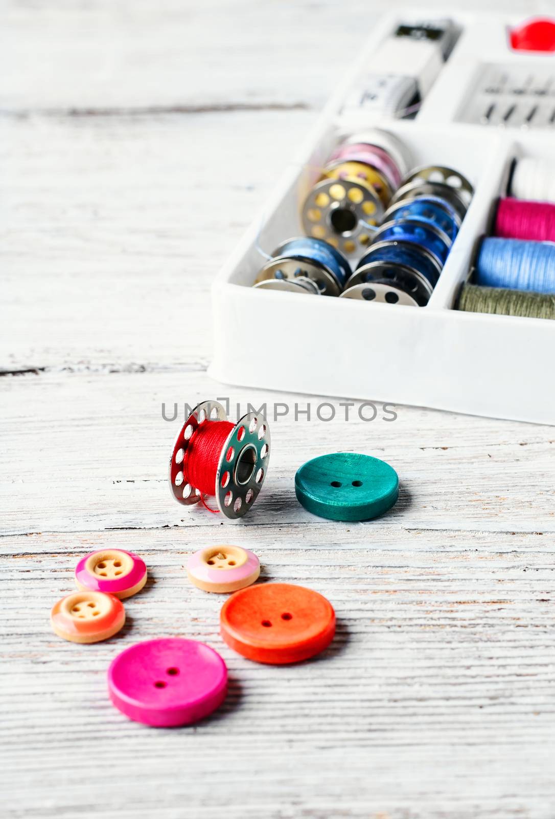 Beads,thread and bobbins for needlework.Picture in light key