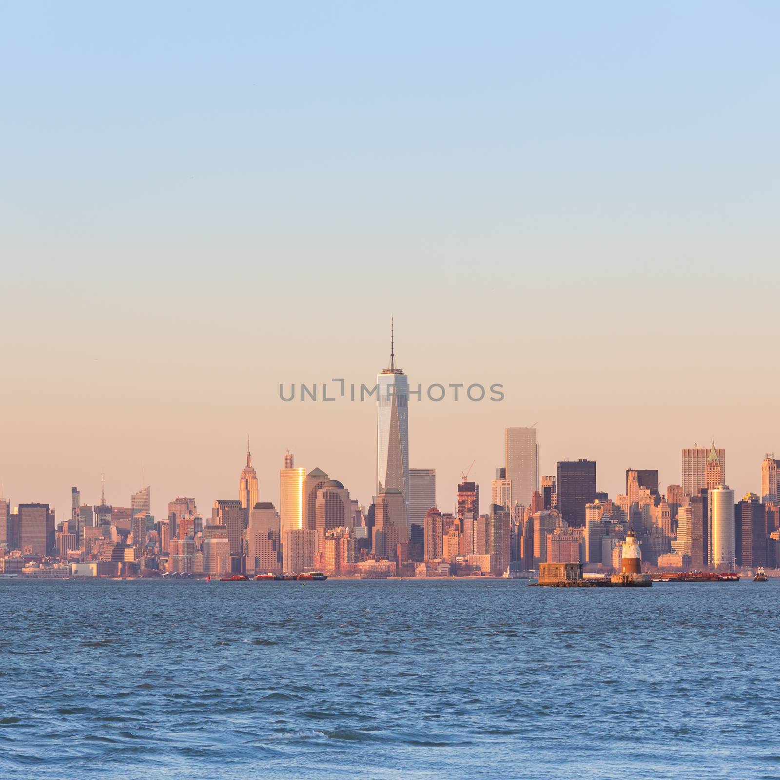 New York City Manhattan downtown skyline at sunset with skyscrapers illuminated over Hudson River panorama. Square composition, copy space.