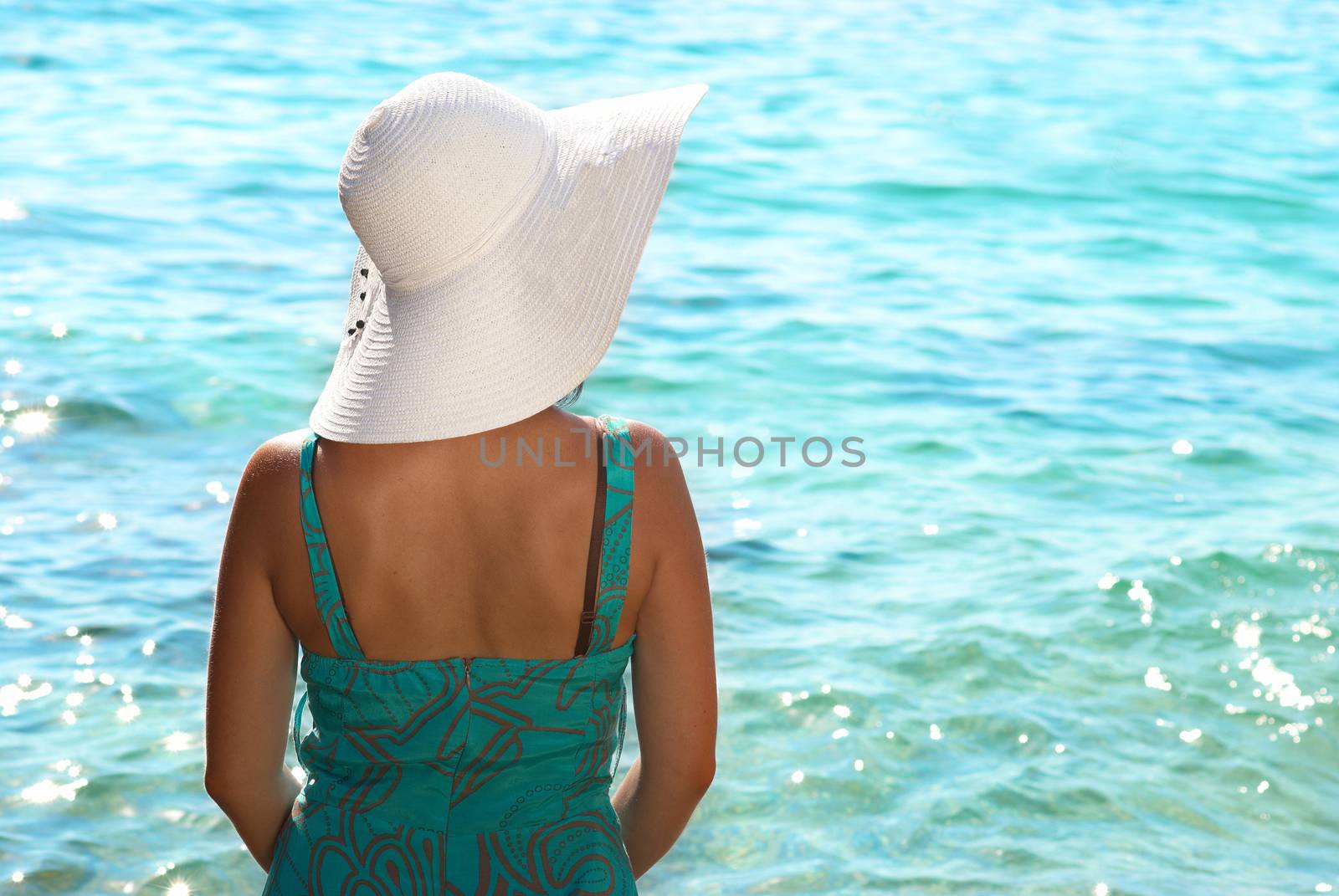 Sitting young woman in the white hat