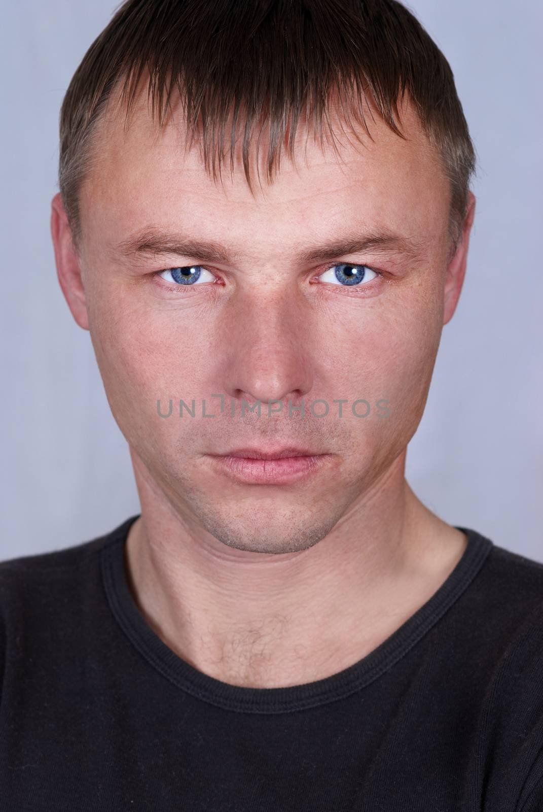 Handsome young man close up portrait on gray background