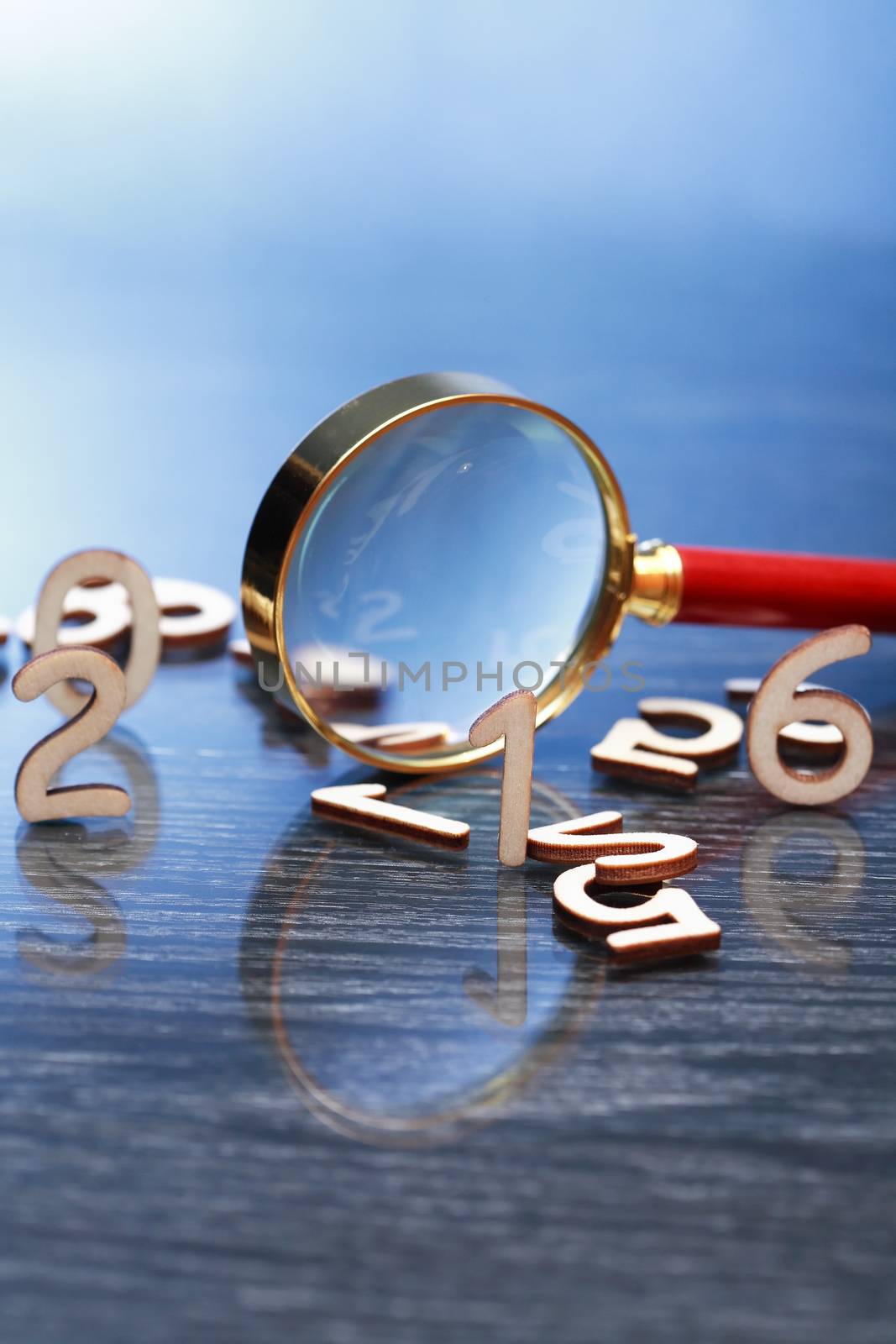 Investigation concept. Magnifying glass near set of wooden digits