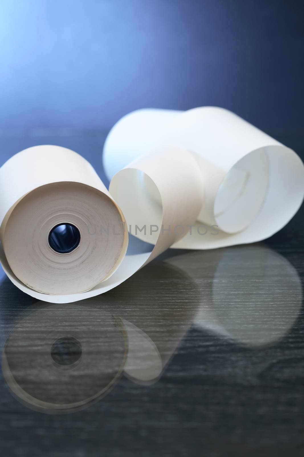 White paper roll with reflection on dark background