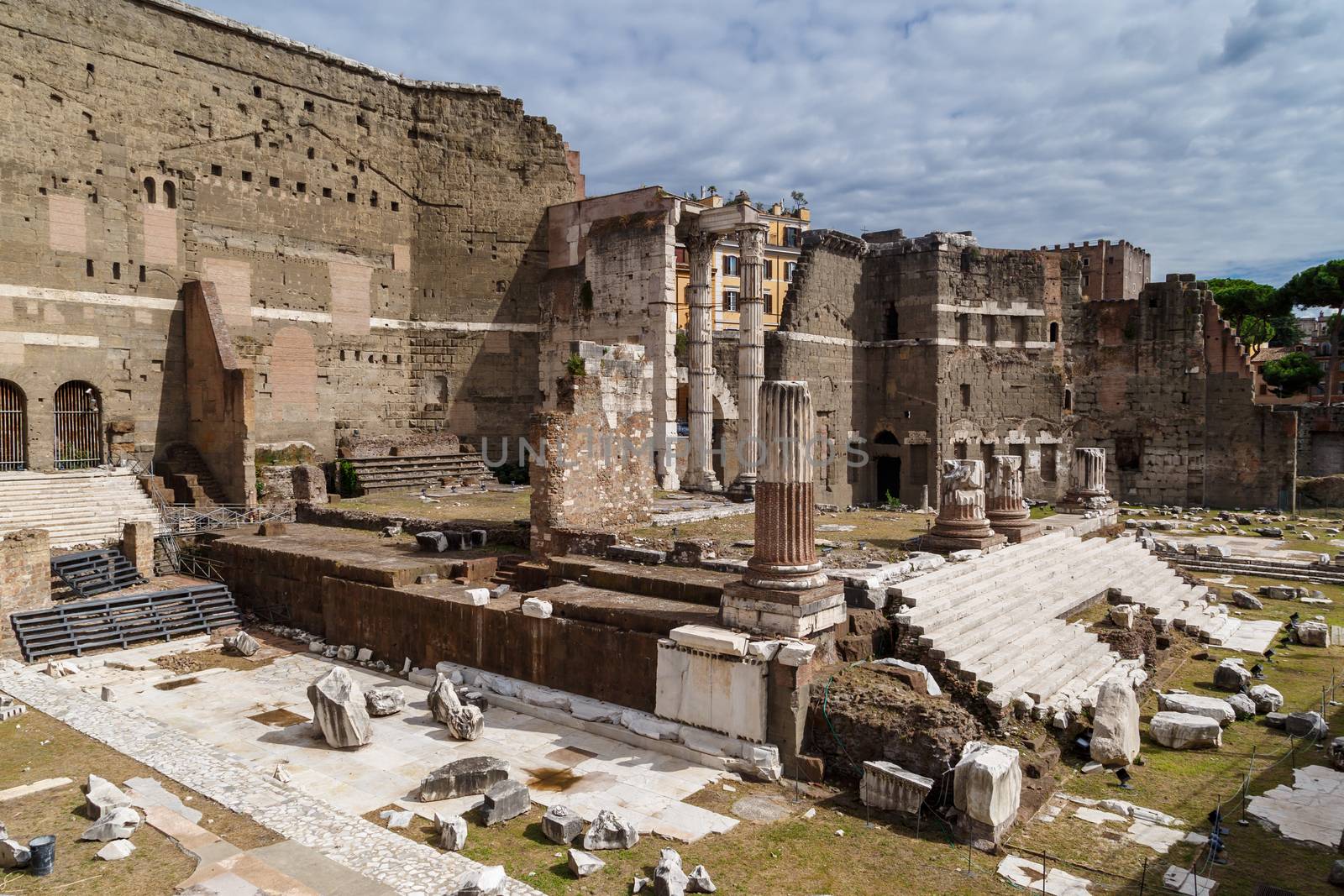 ROME, ITALY - SEPTEMBER 26, 2016 : View of an ancient Roman Forum with columns and ruins around in Rome, with tourists around, on cloudy sky background.
