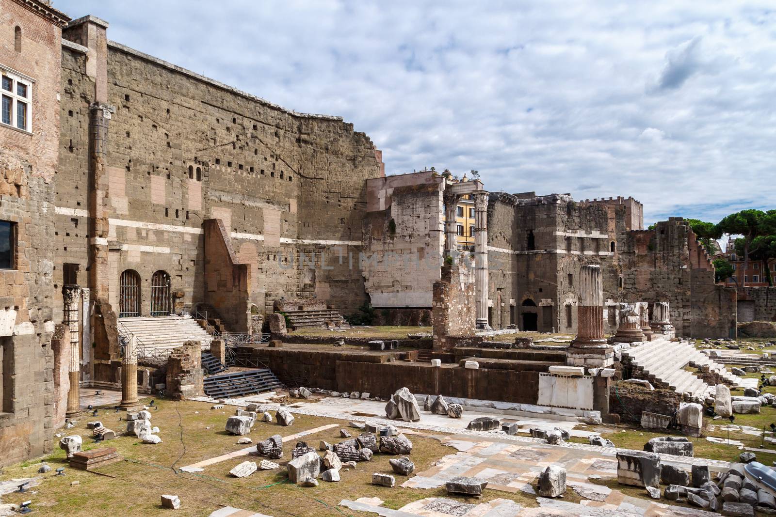 ROME, ITALY - SEPTEMBER 26, 2016 : View of an ancient Roman Forum with columns and ruins around in Rome, with tourists around, on cloudy sky background.
