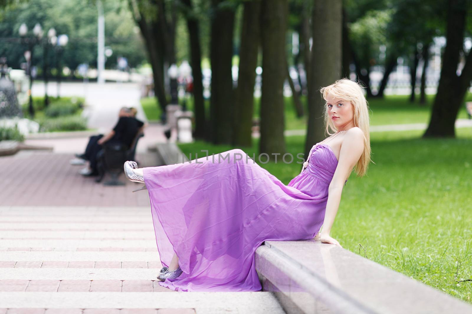 Girl blond sitting on stairs in fasion dress