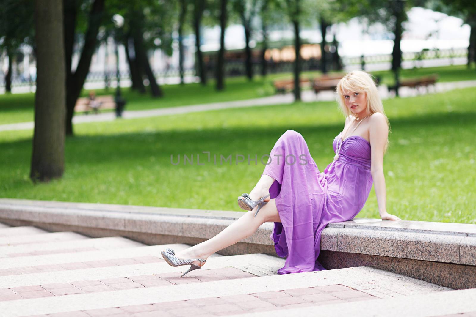 Blond Girl sitting on stairs on fasion dress