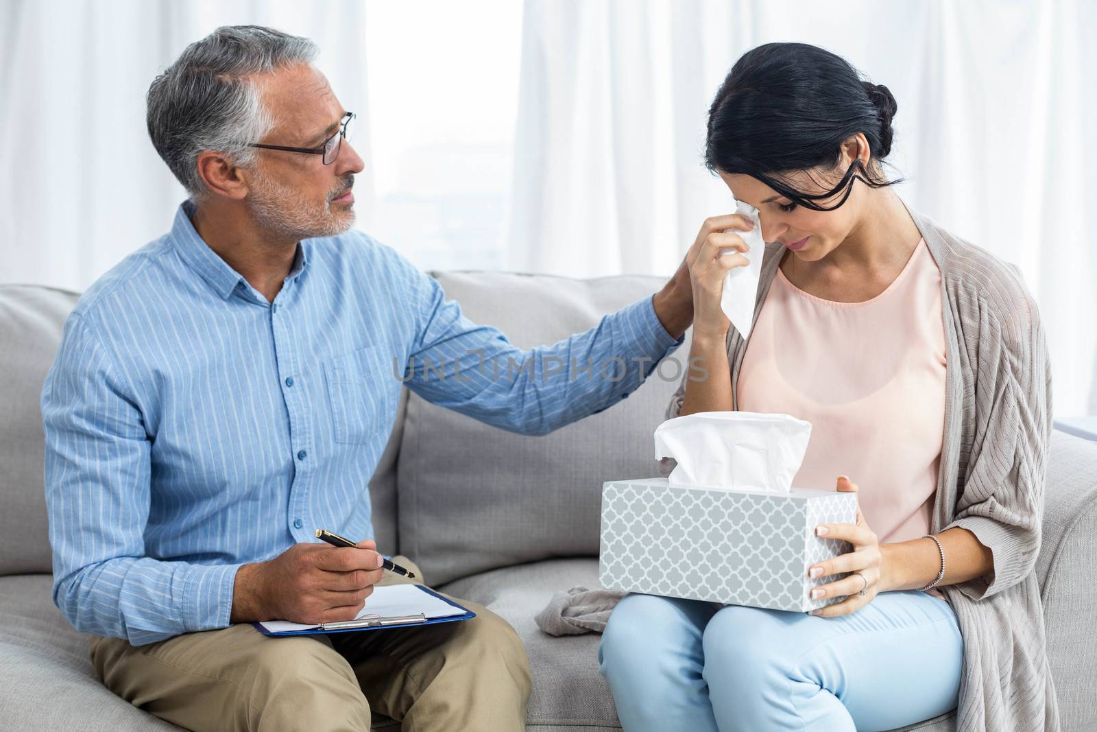 Therapist consoling a woman at home