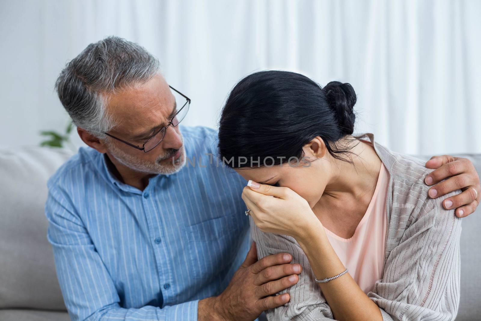 Therapist consoling a woman at home