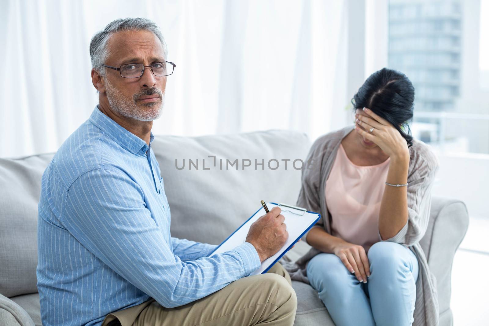 Therapist consoling a woman at home