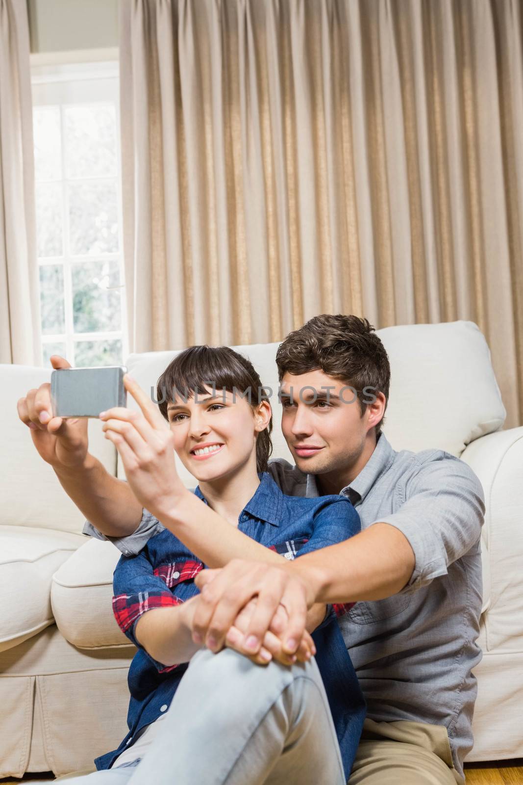Romantic couple taking selfie in their living room