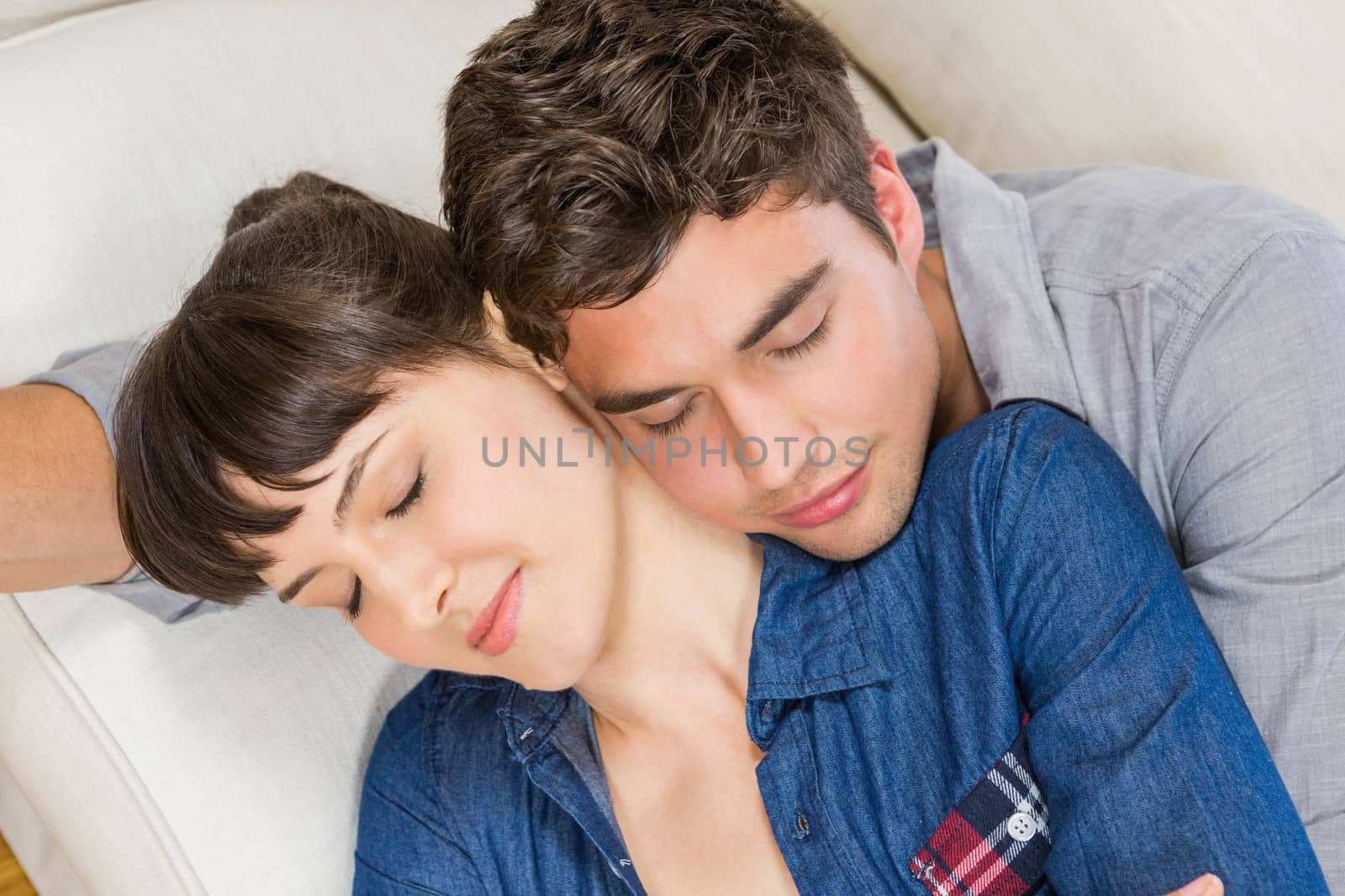 Romantic couple at home relaxing on the sofa in their living room
